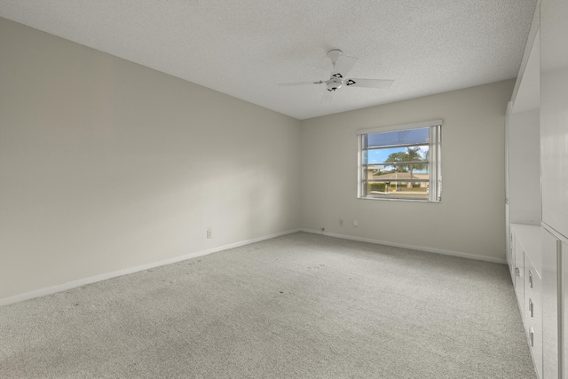 unfurnished room with a textured ceiling, carpet, a ceiling fan, and baseboards