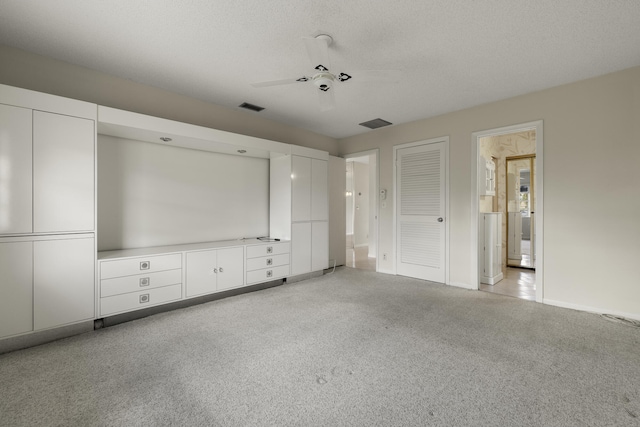 unfurnished bedroom with a textured ceiling, ceiling fan, visible vents, and baseboards