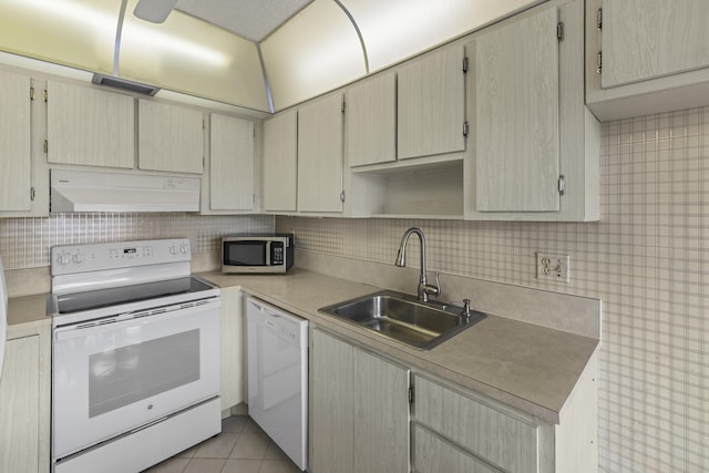 kitchen featuring white appliances, visible vents, decorative backsplash, under cabinet range hood, and a sink