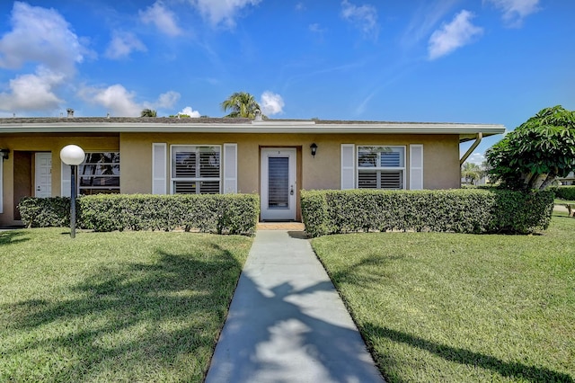 ranch-style house with a front lawn and stucco siding