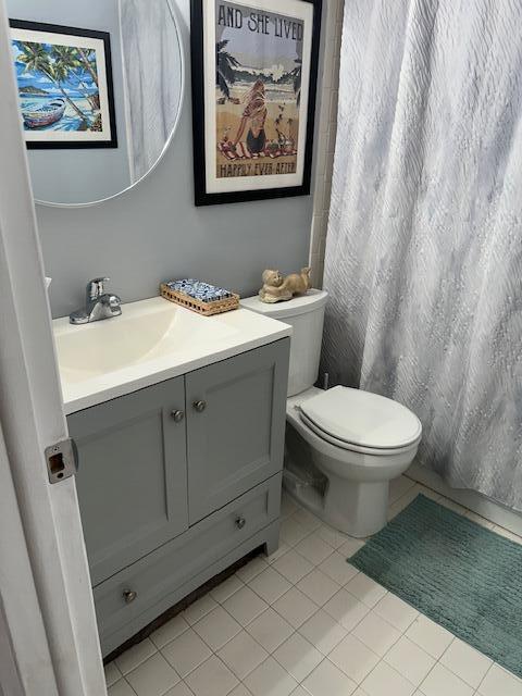 bathroom with tile patterned flooring, toilet, vanity, and a shower with shower curtain