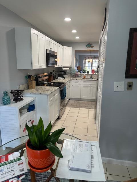 kitchen featuring recessed lighting, white cabinetry, electric range, and light tile patterned flooring