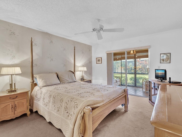 bedroom featuring light carpet, access to exterior, ceiling fan, and a textured ceiling