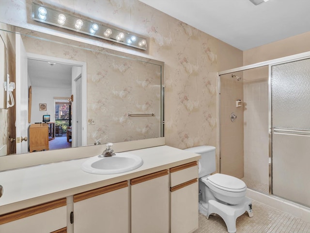 bathroom featuring toilet, wallpapered walls, vanity, and a stall shower