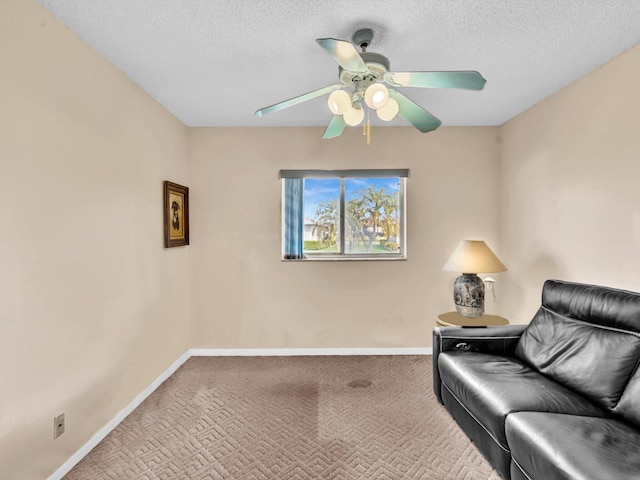 sitting room featuring a ceiling fan, carpet flooring, a textured ceiling, and baseboards