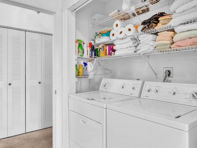 clothes washing area featuring laundry area, light carpet, and washing machine and clothes dryer