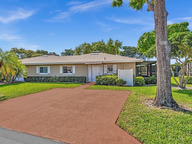 ranch-style house featuring a front lawn and stucco siding