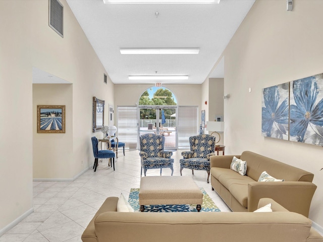 tiled living room featuring visible vents and baseboards