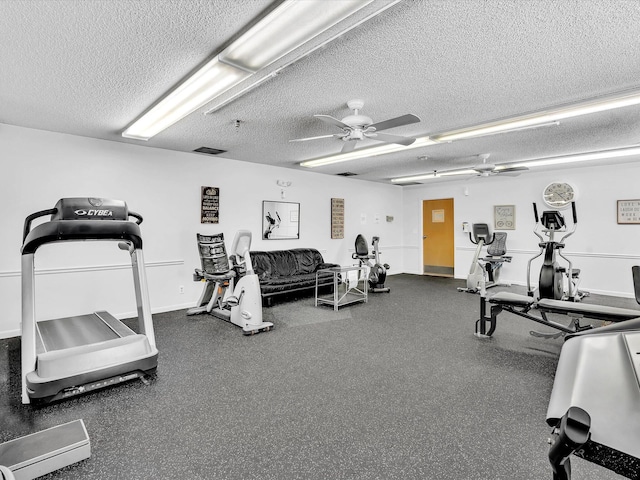 exercise room featuring ceiling fan, baseboards, and a textured ceiling