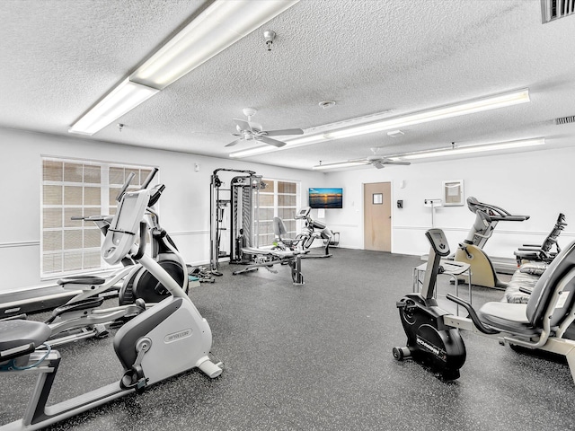 workout area featuring ceiling fan, visible vents, and a textured ceiling