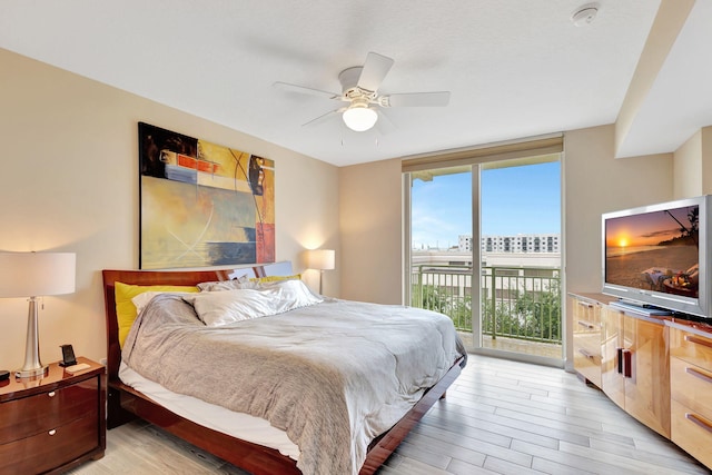 bedroom with a ceiling fan, expansive windows, access to outside, and light wood finished floors