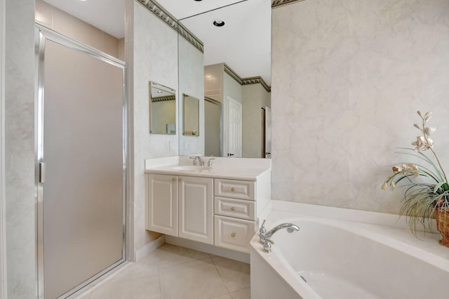 bathroom with a garden tub, a stall shower, tile patterned flooring, and vanity