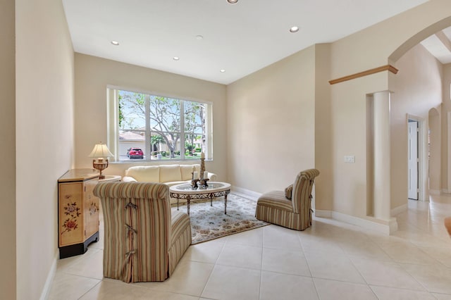 living area with arched walkways, light tile patterned floors, and recessed lighting