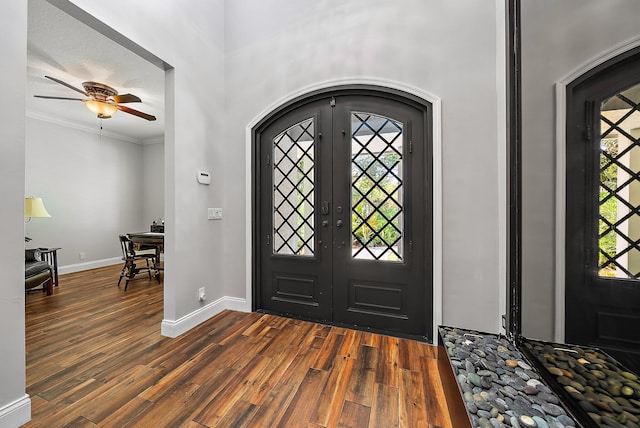 foyer featuring dark wood-type flooring, a wealth of natural light, and ornamental molding