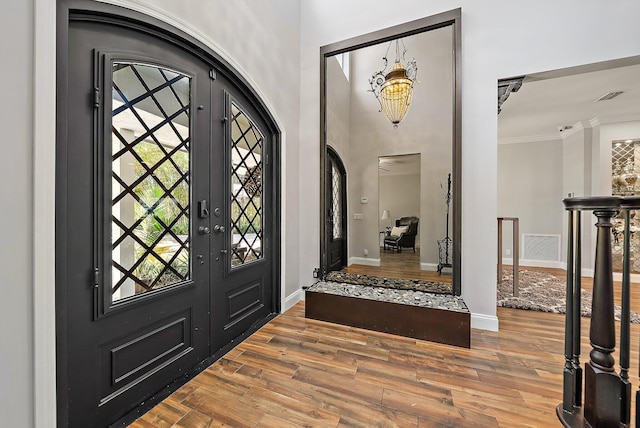 entrance foyer with arched walkways, wood finished floors, and a wealth of natural light