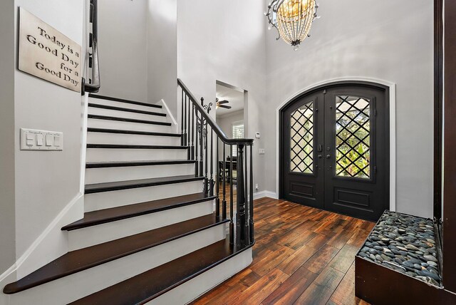 entryway with plenty of natural light, stairway, dark wood finished floors, and french doors