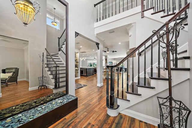 entryway featuring a high ceiling, stairway, wood finished floors, and baseboards