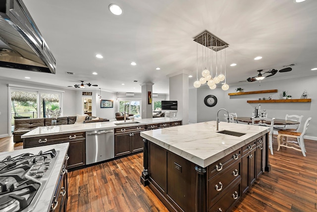 kitchen featuring appliances with stainless steel finishes, open floor plan, a sink, and an island with sink