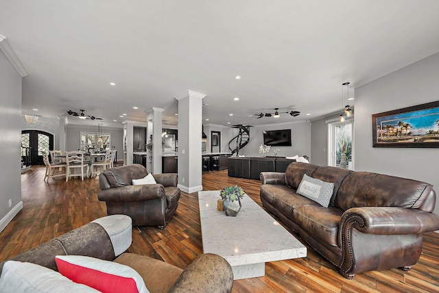 living room with hardwood / wood-style flooring, decorative columns, ornamental molding, and a wealth of natural light