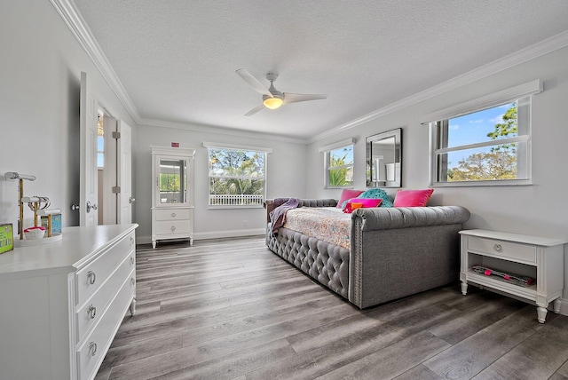 bedroom with a textured ceiling, wood finished floors, and crown molding