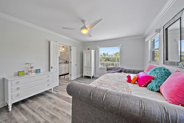 bedroom with a ceiling fan, connected bathroom, ornamental molding, wood finished floors, and a textured ceiling