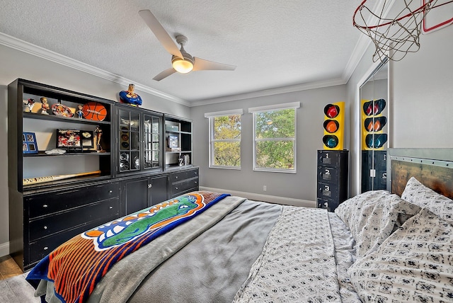 bedroom with a textured ceiling, ceiling fan, ornamental molding, and baseboards