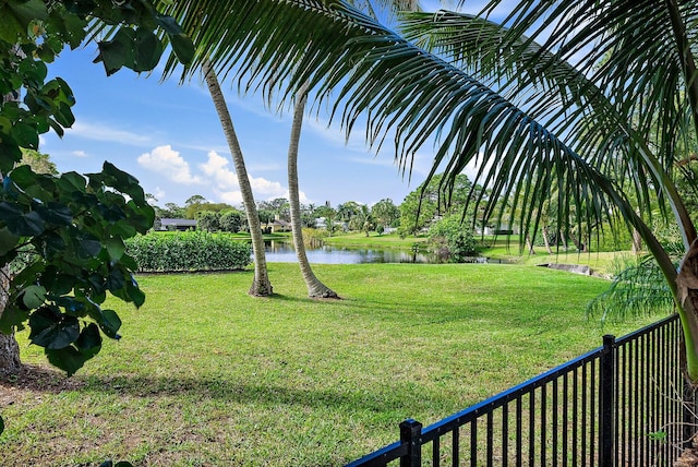 view of yard featuring a water view and fence