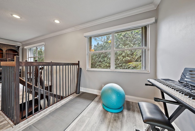 exercise room with recessed lighting, baseboards, crown molding, and wood finished floors