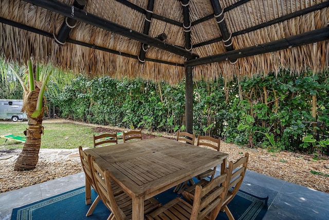 view of patio with a gazebo, fence, and outdoor dining space