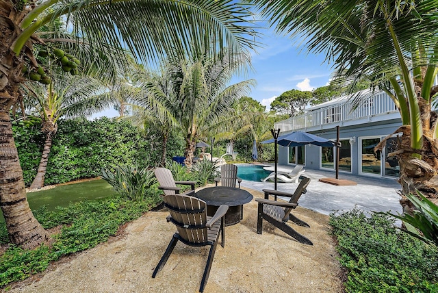 view of patio / terrace featuring a balcony and an outdoor pool