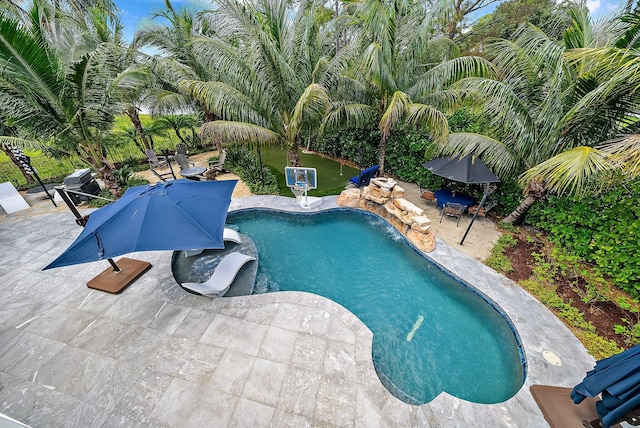 outdoor pool with area for grilling and a patio