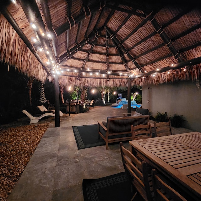 patio at night with a gazebo and an outdoor living space