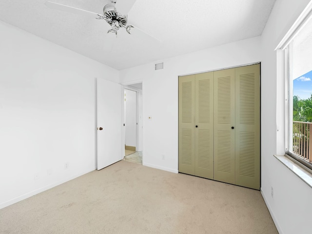 unfurnished bedroom with a closet, carpet flooring, a ceiling fan, baseboards, and visible vents