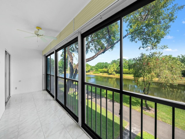 unfurnished sunroom with tile patterned floors and a water view