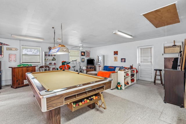 recreation room featuring ceiling fan, a textured ceiling, a wall unit AC, light colored carpet, and billiards