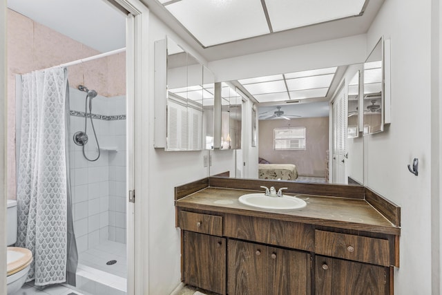 ensuite bathroom with toilet, ensuite bathroom, a stall shower, ceiling fan, and vanity