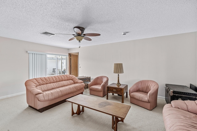 living area featuring ceiling fan, a textured ceiling, light carpet, visible vents, and baseboards