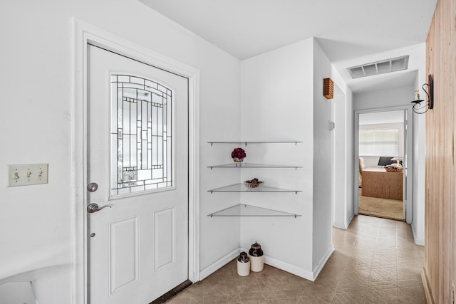 foyer featuring tile patterned floors, visible vents, and baseboards