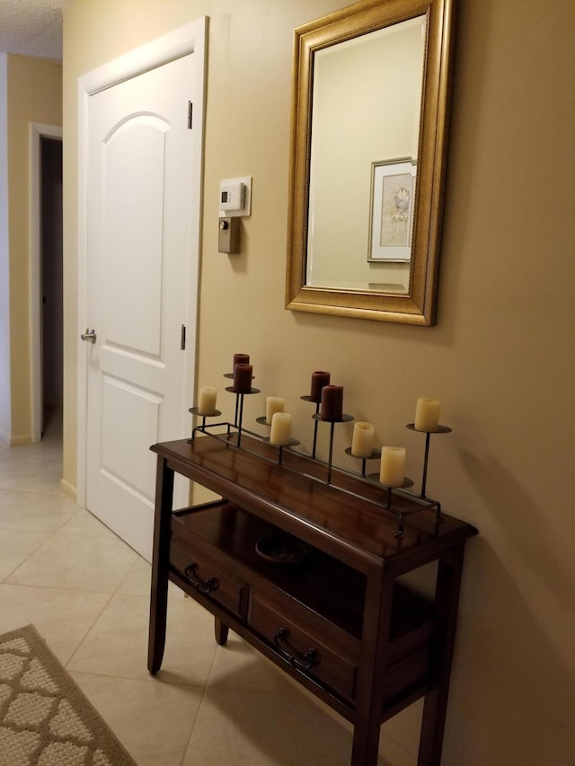 corridor featuring baseboards and light tile patterned floors