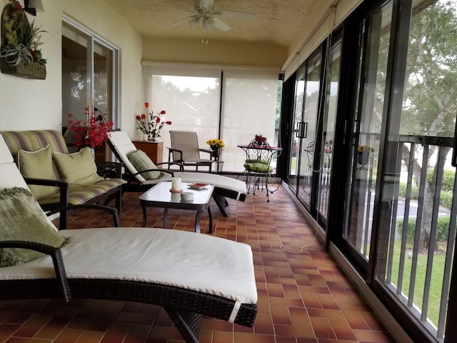 sunroom / solarium featuring a ceiling fan