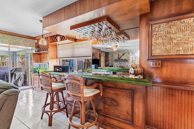 interior space with ceiling fan, wood walls, and tile patterned floors
