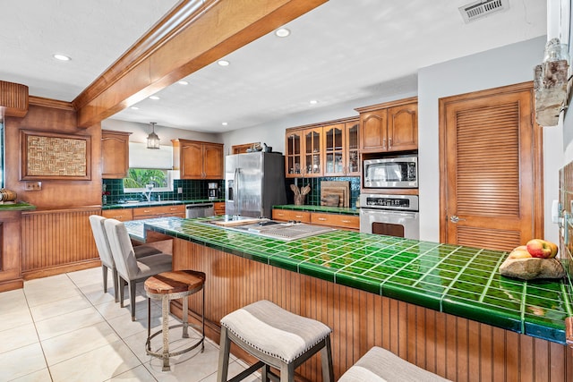 kitchen with a breakfast bar, visible vents, backsplash, appliances with stainless steel finishes, and recessed lighting