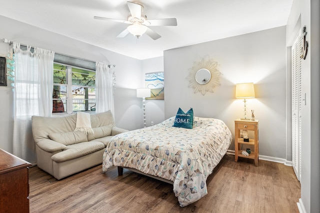 bedroom featuring ceiling fan, baseboards, and wood finished floors