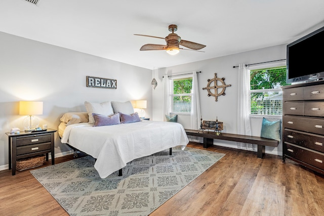 bedroom featuring ceiling fan, baseboards, and wood finished floors