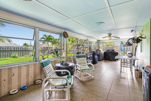 sunroom / solarium featuring tile patterned flooring and ceiling fan