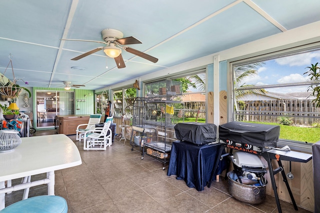 sunroom with a hot tub, ceiling fan, and tile patterned floors