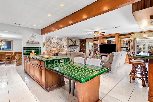 interior space with tile counters, ceiling fan, light tile patterned flooring, and visible vents