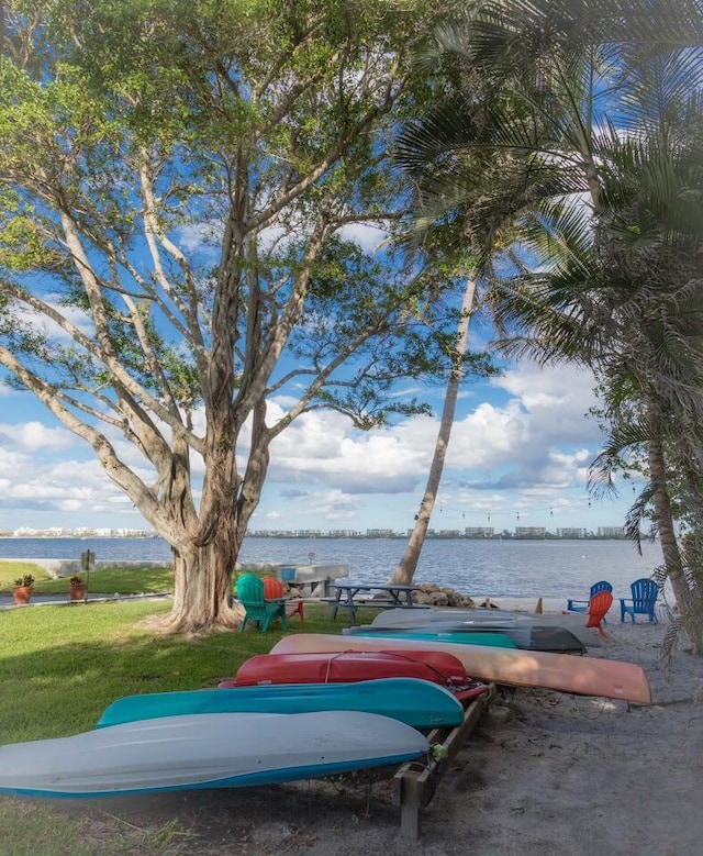 view of property's community featuring a lawn and a water view