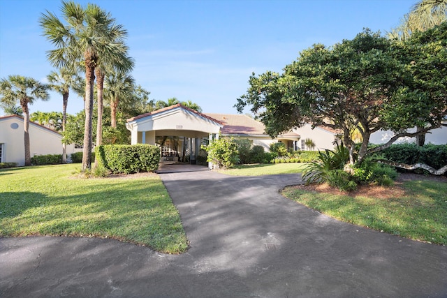 view of front of property featuring a carport, driveway, and a front lawn