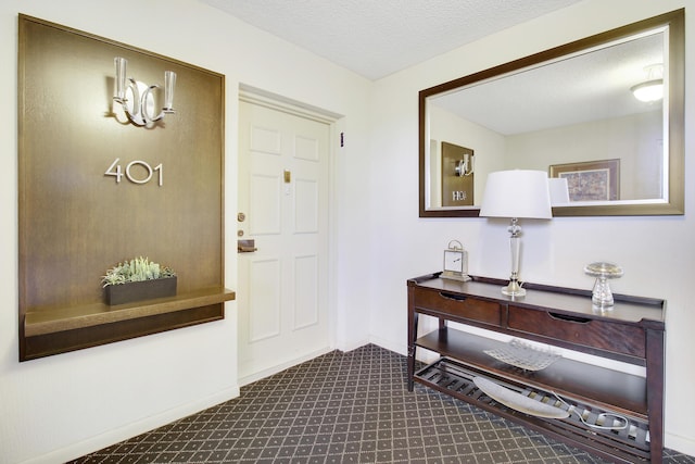 foyer featuring a textured ceiling and baseboards